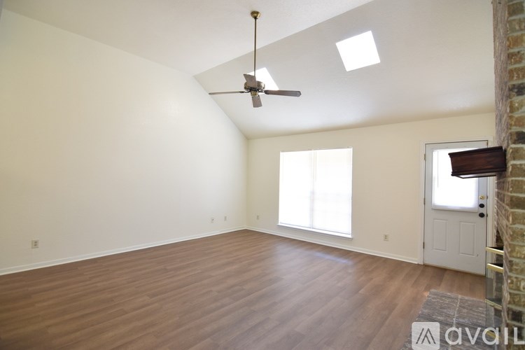 A room with a ceiling fan and wooden flooring.