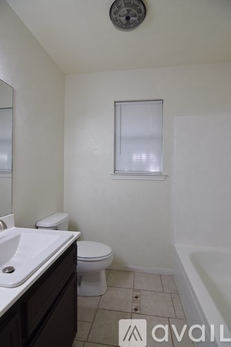 A bathroom with a toilet, sink, and bathtub.