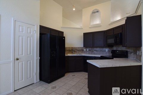 A kitchen with black cabinets and appliances is available for rent.