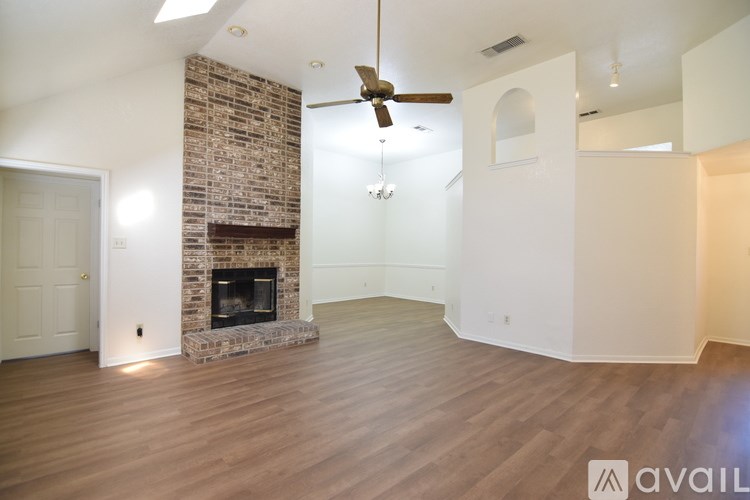 A living room with a fireplace and a ceiling fan.