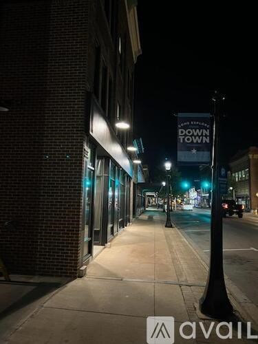 A dark street with a sign that says "DOWNTOWN" on it.