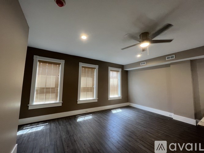 A room with a ceiling fan and wooden flooring.
