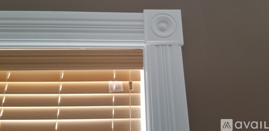 A close up of a window with blinds and a white frame.