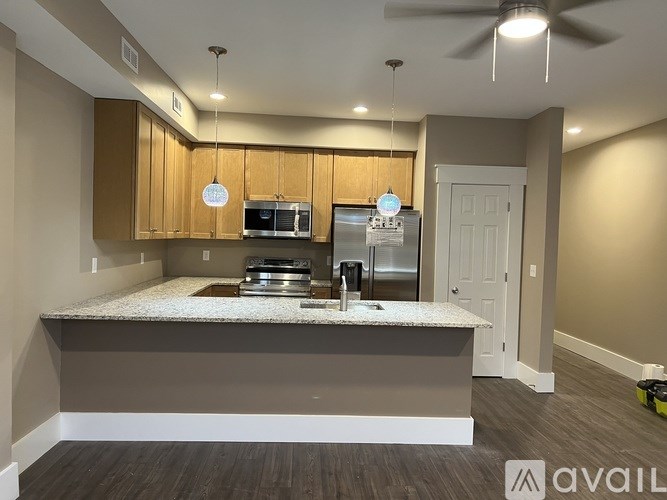 A kitchen with a granite countertop and wooden cabinets.