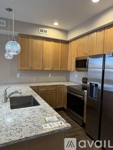 A kitchen with wooden cabinets and granite countertops.
