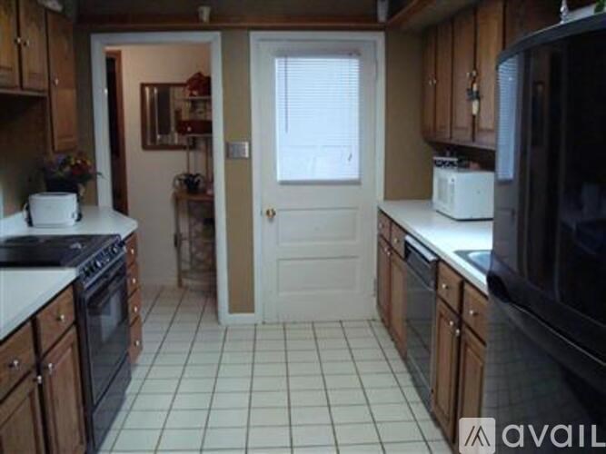 A kitchen with wooden cabinets and black appliances.