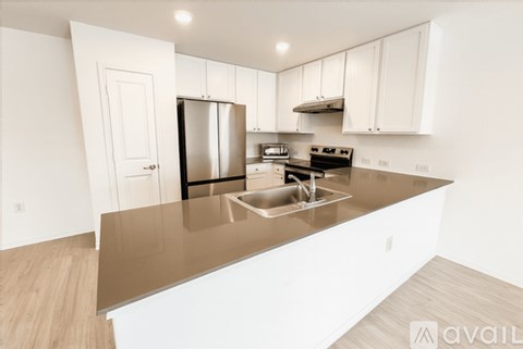 A kitchen with white cabinets and a stainless steel refrigerator.
