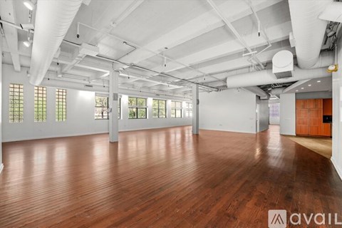 A large empty room with wooden floors and white walls.