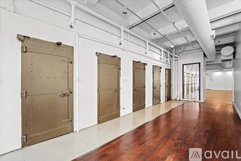 A long hallway with doors on both sides and a wooden floor.