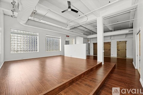 A spacious room with wooden floors and white walls.