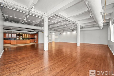 A large empty room with wooden floors and white walls.