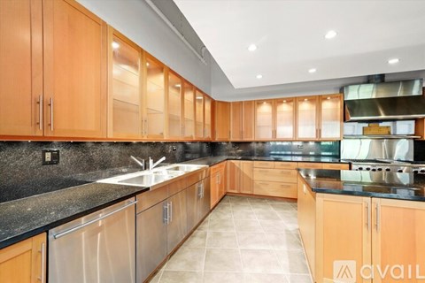 A kitchen with wooden cabinets and a black countertop.