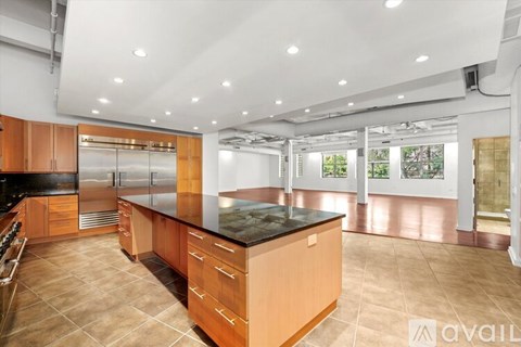 A spacious kitchen with wooden cabinets and a black countertop.