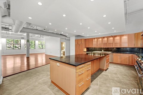 A kitchen with wooden cabinets and a black countertop.