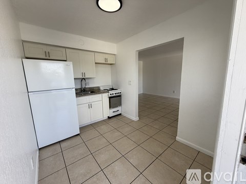 A kitchen with white appliances and cabinets.