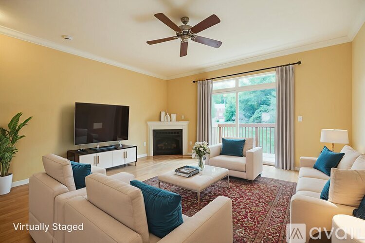 A living room with a television, two couches, and a ceiling fan.