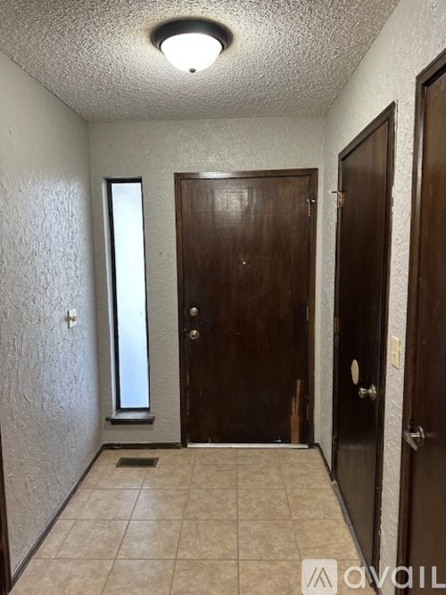 A hallway with two doors and a window.