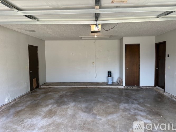 A large empty room with a concrete floor and white walls.