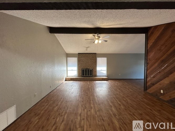 A room with wooden floors and a ceiling fan.