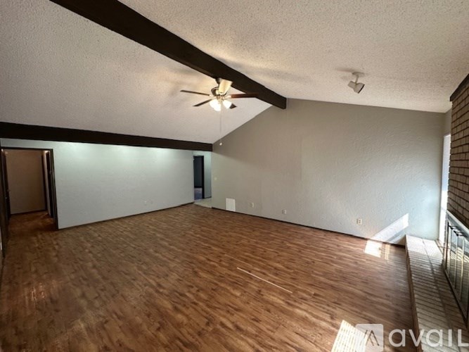A room with wooden flooring and a ceiling fan.