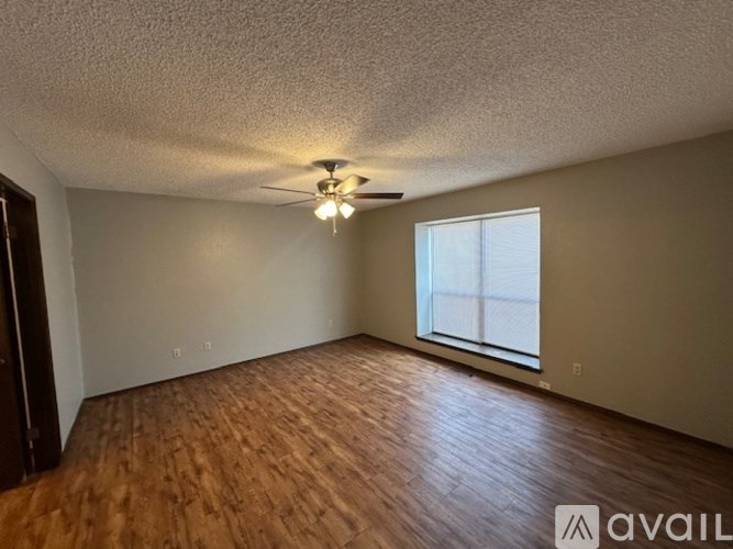 A room with wooden flooring and a window.