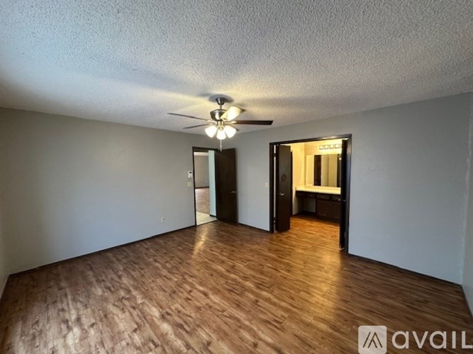 A room with wooden flooring and a ceiling fan.