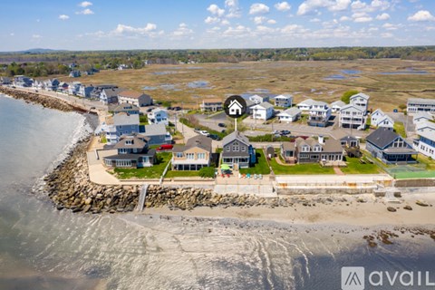 A bird's eye view of a coastal residential area with houses built on stilts.