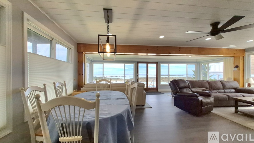 A beachside picnic area with tables and chairs overlooking the ocean.