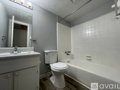 A white toilet sits next to a bathtub in a bathroom.