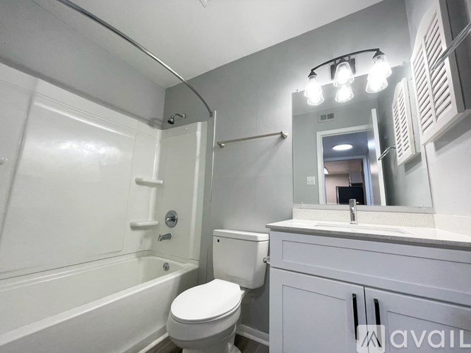 A bathroom with a toilet, sink, and mirror.