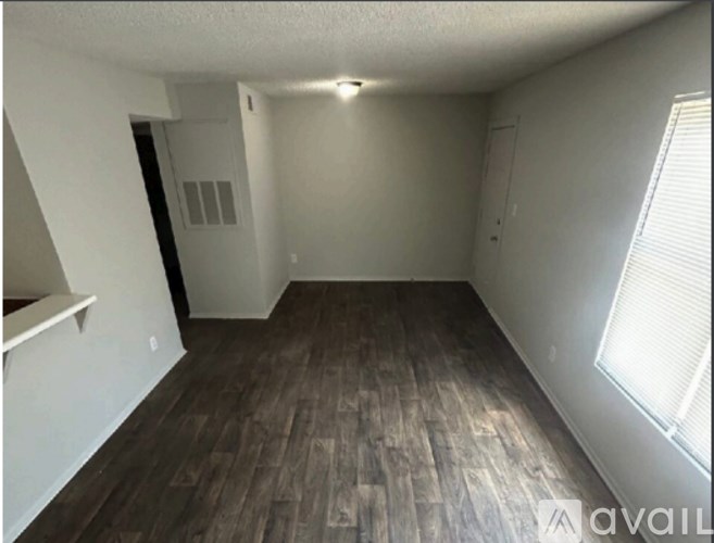 A room with wooden flooring and white walls.