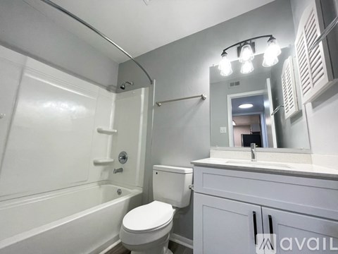 A bathroom with a toilet, sink, and mirror.