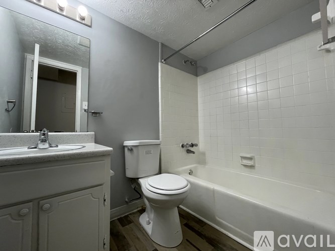 A white toilet sits next to a bathtub in a bathroom.