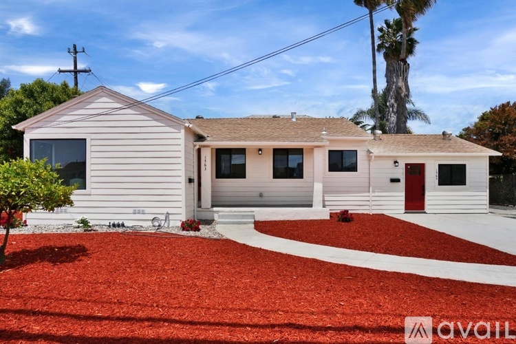A house with a red mulch driveway is for sale.