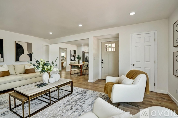 A living room with a white couch, a coffee table, and a rug.