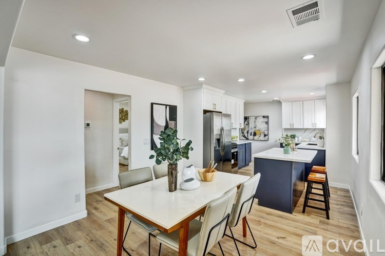 A dining room with a white table and chairs.