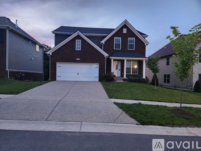 A two-story house with a garage is available for sale.