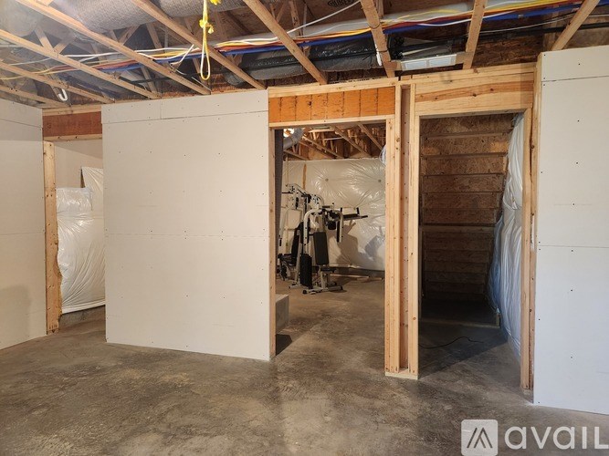A room under construction with exposed wooden beams and unfinished walls.