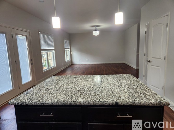 A kitchen island with a granite countertop and a black drawer unit.