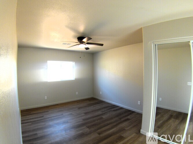 A room with a ceiling fan and a door.