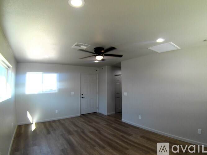 A room with a ceiling fan and a door.