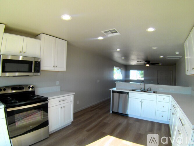 A kitchen with white cabinets and a black stove top oven.