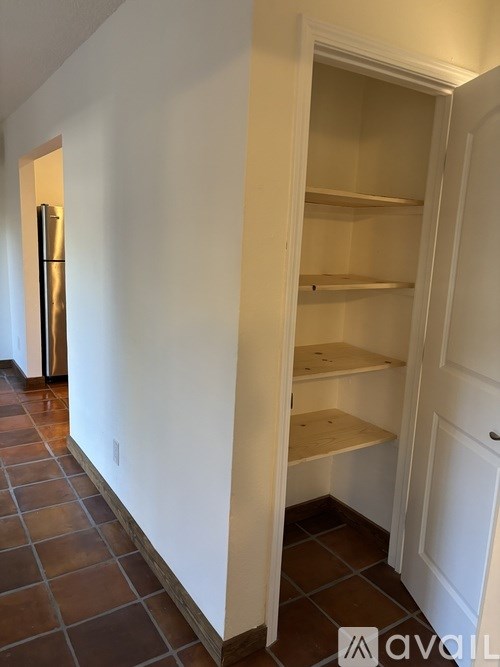 A kitchen with a white wall and a white door.
