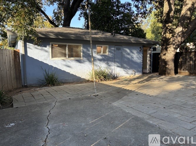 A house with a cracked driveway and a tree in front.