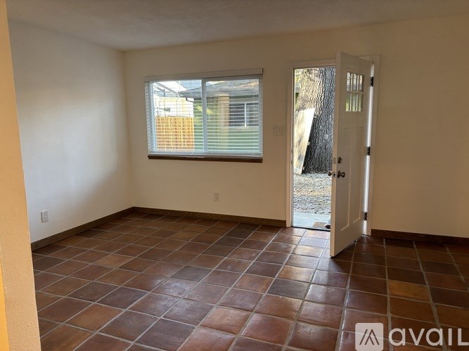 A room with a tiled floor and a door leading outside.