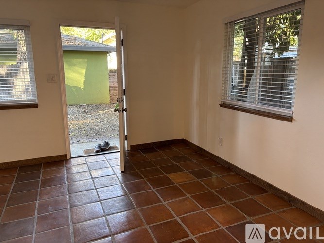 A room with a tiled floor and a door leading outside.