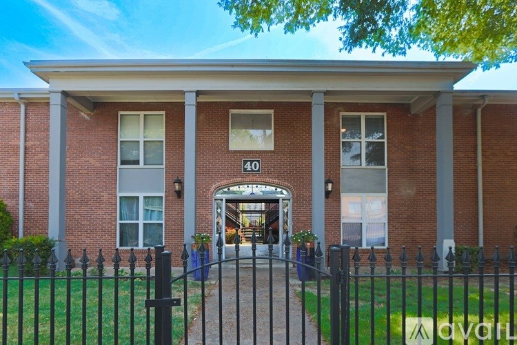 A brick building with a black fence in front.