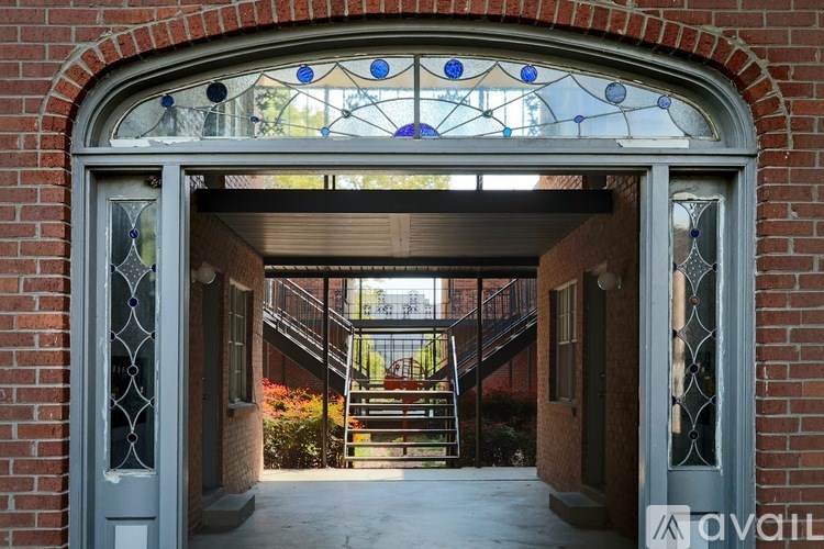 A brick building with a stained glass window above the door.