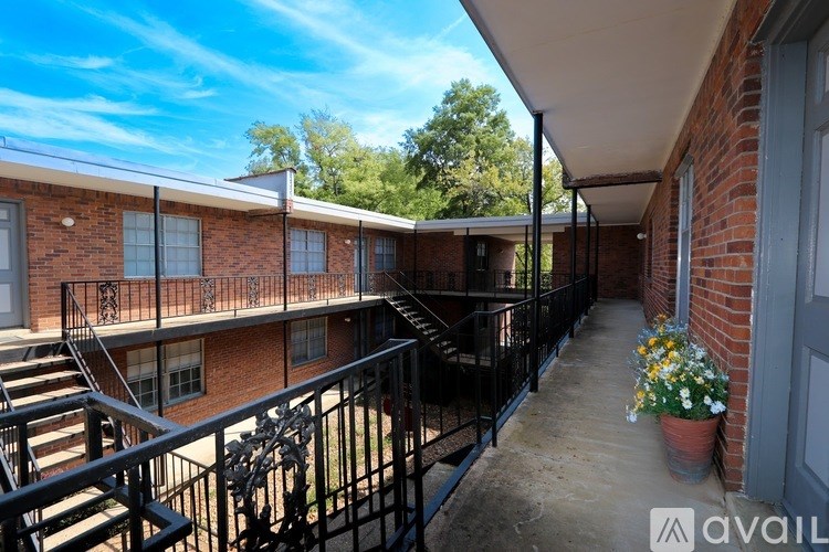 A balcony with a metal railing and potted plants.