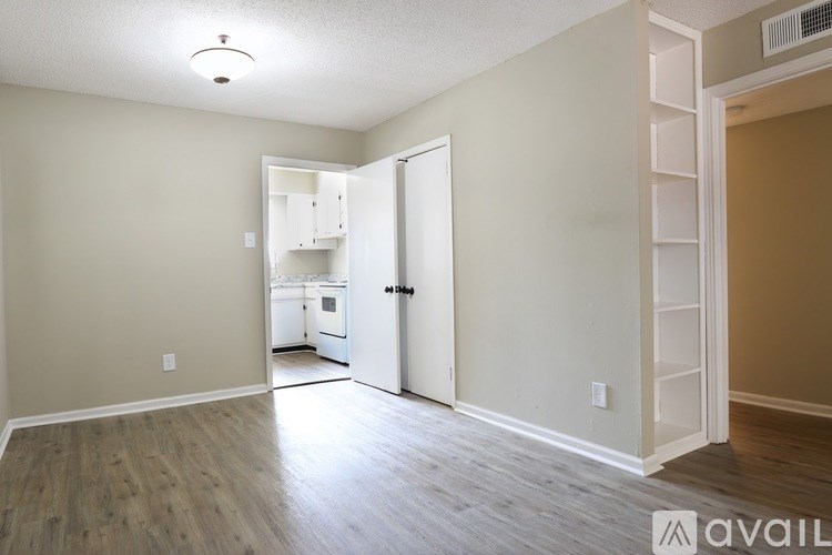 A room with a white door and a wooden floor.